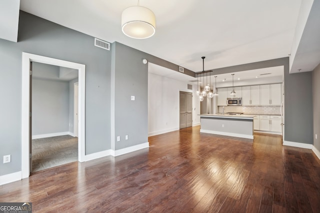 unfurnished living room with dark wood-type flooring and sink