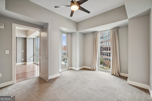 carpeted spare room featuring ceiling fan