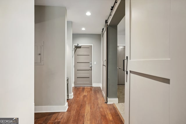 hall with hardwood / wood-style floors and a barn door