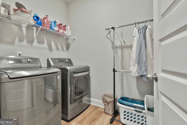 laundry area with independent washer and dryer and light hardwood / wood-style floors