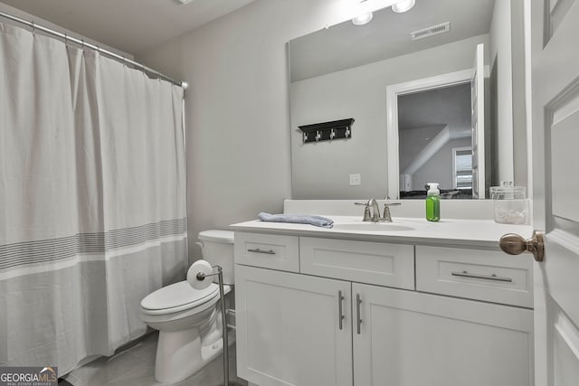 bathroom featuring tile patterned flooring, vanity, and toilet