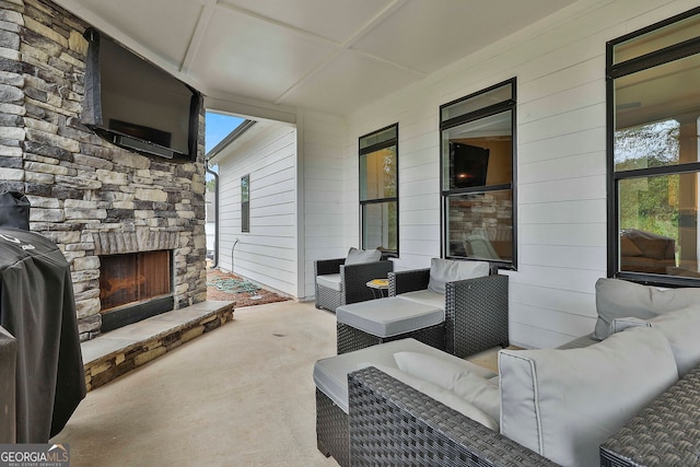 view of patio / terrace with an outdoor living space with a fireplace and grilling area