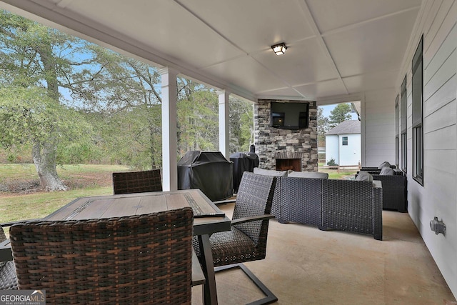 view of patio featuring an outdoor living space with a fireplace and a grill