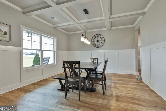 dining area with beam ceiling, crown molding, light hardwood / wood-style floors, and coffered ceiling