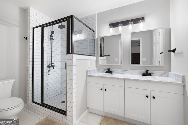 bathroom with vanity, a shower with door, tile patterned floors, and toilet