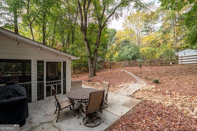 view of patio / terrace with a grill and a storage shed