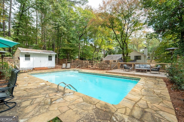 view of pool featuring a patio, an outdoor living space, an outdoor structure, and a deck