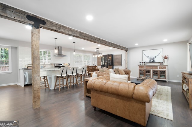 living room with plenty of natural light, dark hardwood / wood-style flooring, and decorative columns