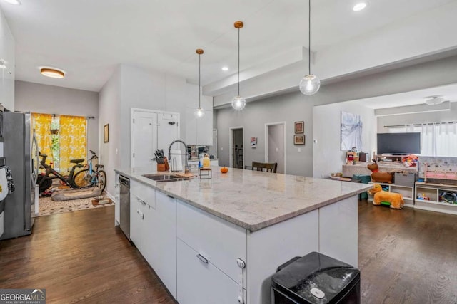 kitchen with dark hardwood / wood-style flooring, white cabinets, a kitchen island with sink, appliances with stainless steel finishes, and decorative light fixtures