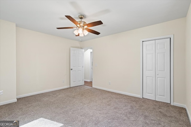 unfurnished bedroom with ceiling fan, light carpet, and a closet