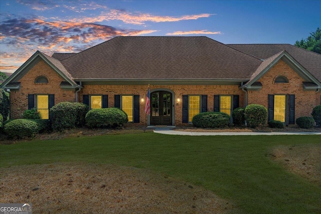 view of front of home featuring french doors and a yard