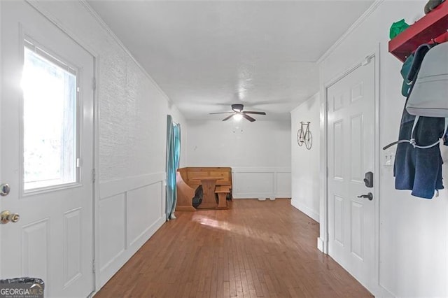 hallway with ornamental molding and hardwood / wood-style floors