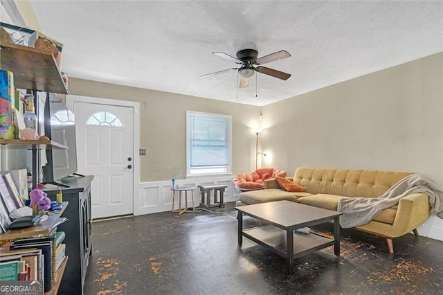 living room with a wealth of natural light, ceiling fan, and a textured ceiling