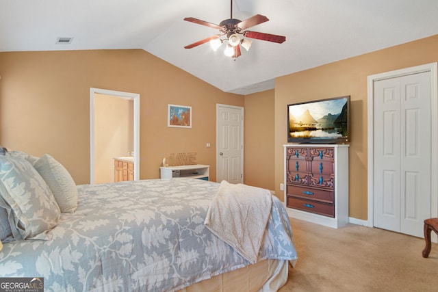 bedroom featuring connected bathroom, vaulted ceiling, light colored carpet, and ceiling fan