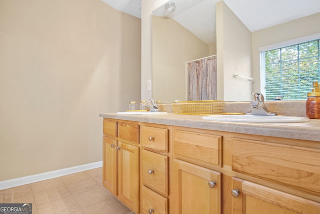 bathroom with tile patterned flooring, vanity, and lofted ceiling