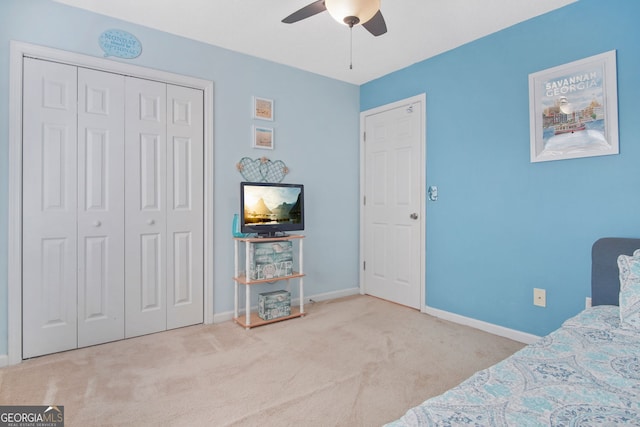 carpeted bedroom with ceiling fan and a closet