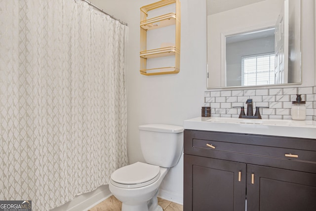 bathroom featuring vanity, toilet, and decorative backsplash