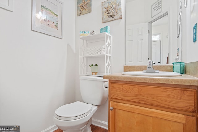 bathroom featuring toilet, vanity, and wood-type flooring