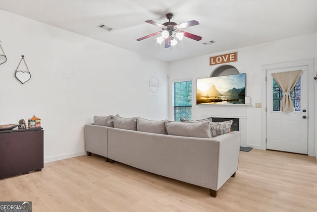 living room with ceiling fan and light hardwood / wood-style flooring