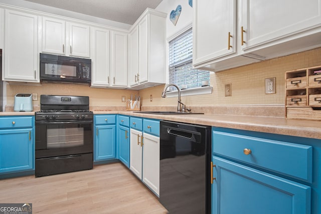 kitchen featuring light hardwood / wood-style floors, white cabinetry, sink, black appliances, and blue cabinets