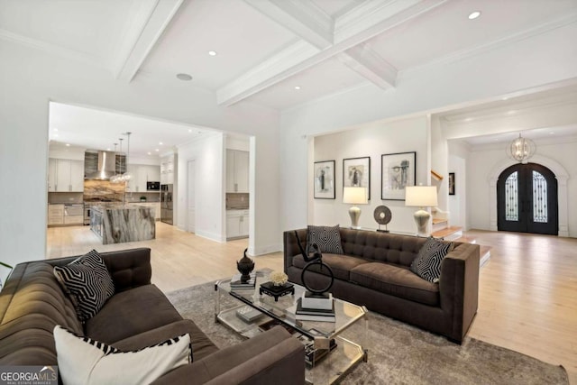 living room with light hardwood / wood-style floors, beam ceiling, and french doors