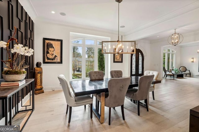 dining area featuring ornamental molding, light hardwood / wood-style floors, and an inviting chandelier