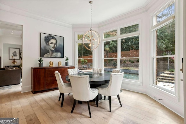 dining space featuring light wood-type flooring, a chandelier, and a healthy amount of sunlight