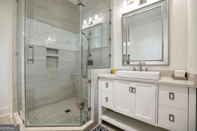 bathroom featuring an enclosed shower, vanity, and wood-type flooring