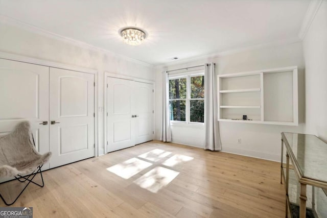 interior space featuring light wood-type flooring and crown molding