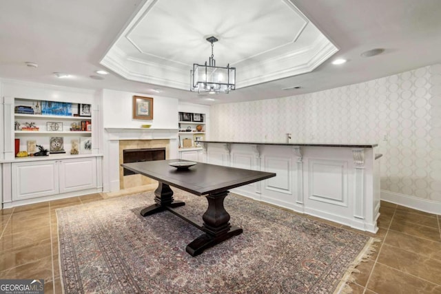 playroom featuring built in features, tile patterned floors, a tray ceiling, and an inviting chandelier