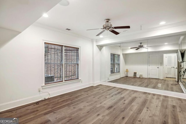 unfurnished living room with hardwood / wood-style floors, ceiling fan, and ornamental molding