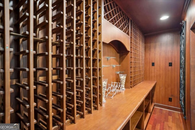 wine room with wooden walls and hardwood / wood-style flooring