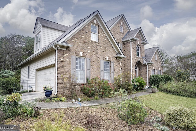 view of property featuring a garage and a front lawn