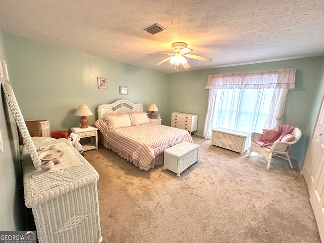 carpeted bedroom featuring a textured ceiling and ceiling fan