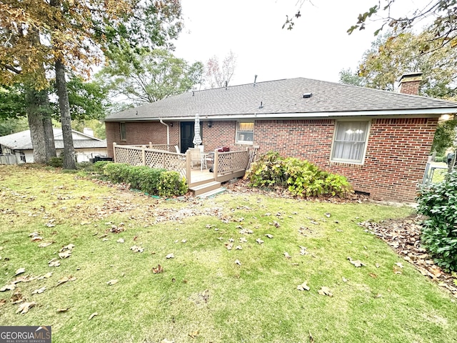 back of property featuring a lawn and a deck