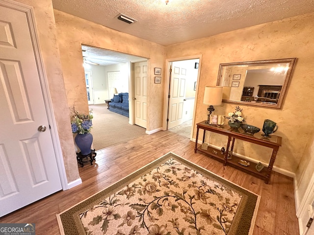 hallway featuring wood-type flooring and a textured ceiling