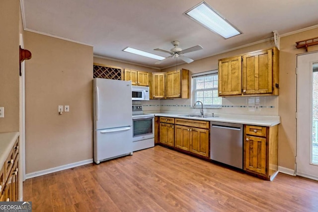 kitchen featuring light hardwood / wood-style floors, sink, tasteful backsplash, ceiling fan, and white appliances