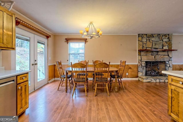 dining room featuring a fireplace, light hardwood / wood-style floors, a chandelier, and ornamental molding