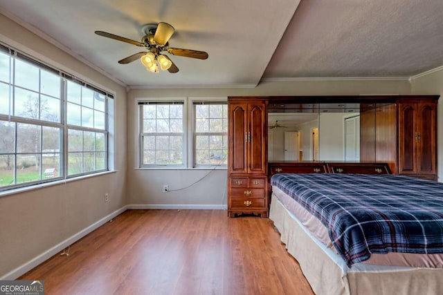 unfurnished bedroom featuring ceiling fan, light hardwood / wood-style flooring, and crown molding