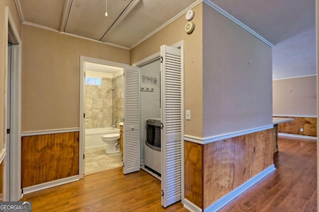 hallway featuring wood walls, hardwood / wood-style flooring, and ornamental molding