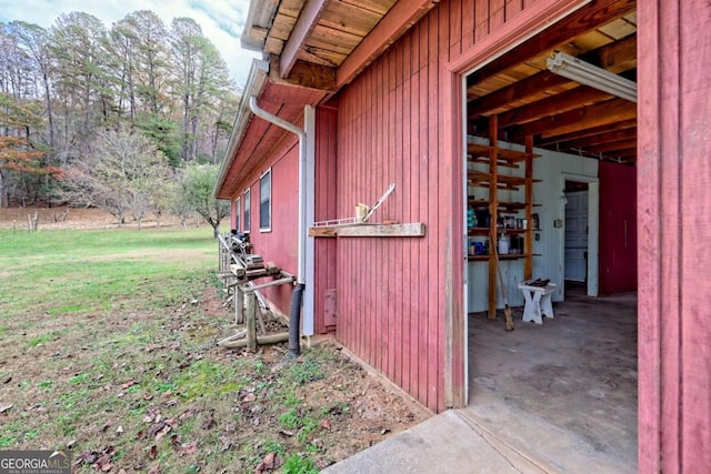 view of property exterior with an outdoor structure and a yard