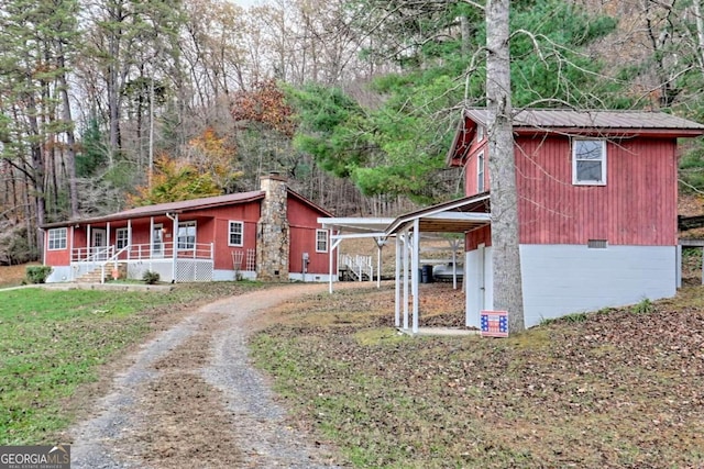 view of side of home featuring covered porch