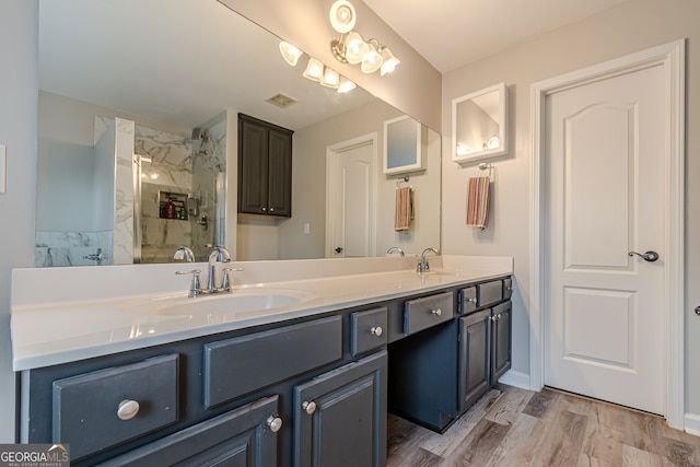 bathroom with vanity, hardwood / wood-style flooring, and a tile shower