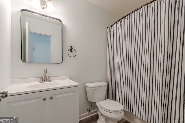 bathroom featuring walk in shower, vanity, and toilet