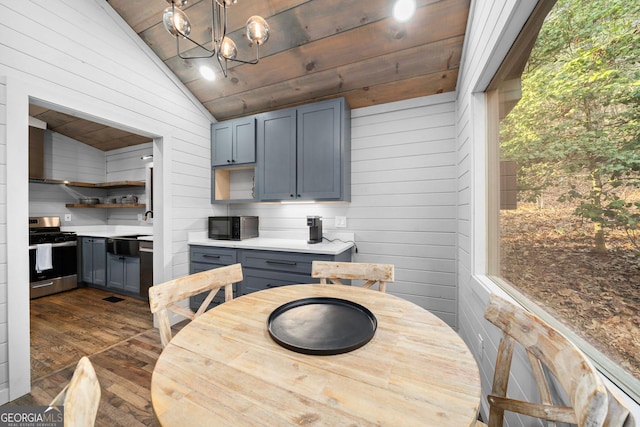 dining space with lofted ceiling, wood ceiling, dark wood-style flooring, an inviting chandelier, and wood walls