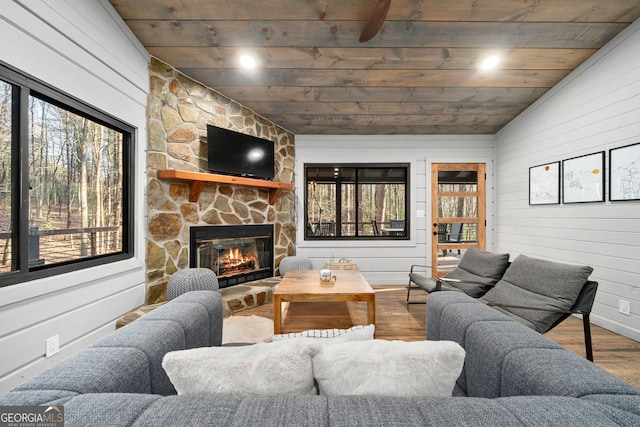 living room featuring lofted ceiling, wooden ceiling, a fireplace, and a wealth of natural light