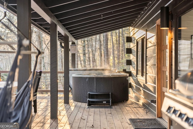 wooden terrace featuring a hot tub and central air condition unit