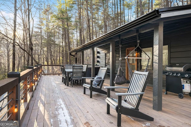 deck with outdoor dining area and grilling area