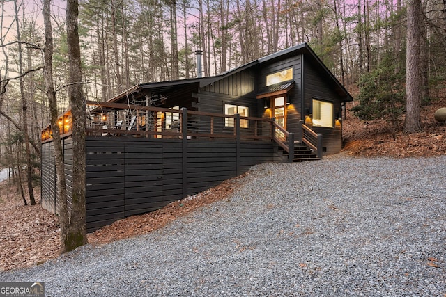 chalet / cabin with board and batten siding, driveway, and a wooden deck