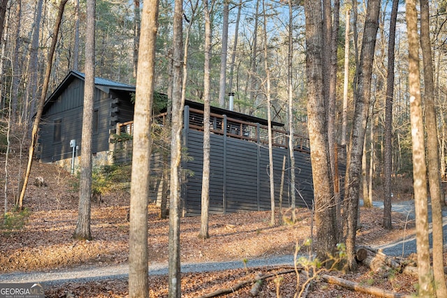 view of side of property featuring a wooded view